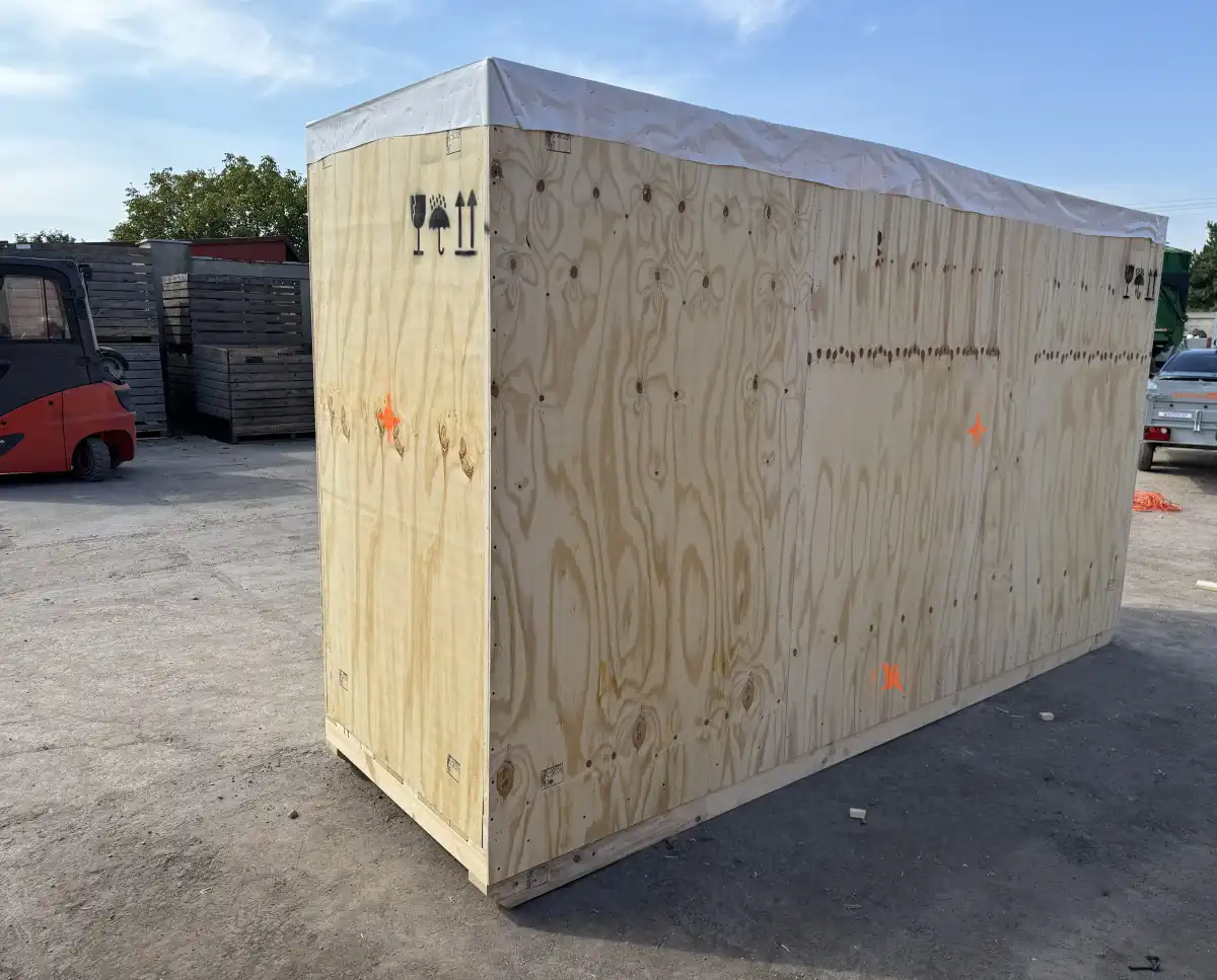 Maszyna opakowana w skrzynię do transportu morskiego, z oznaczeniami eksportowymi